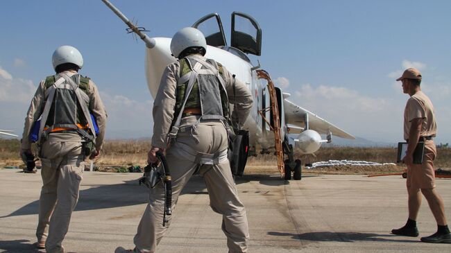 Российские летчики перед полетом у самолета Су-24 на авиабазе Хмеймим в Сирии